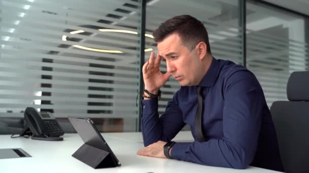 Konzentrierte junge Geschäftsmann hält Videoanruf mit Kunden auf Laptop in moder Büro — Stockvideo