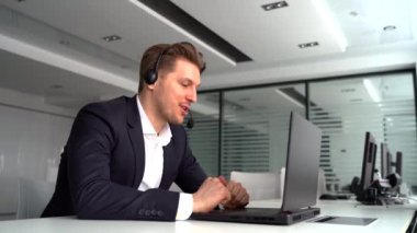 Milenyum Kafkasyalı erkek çalışanın ofisinde dizüstü bilgisayarında görüntülü arama var.