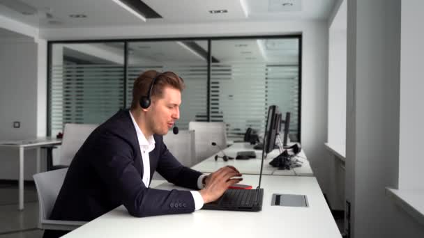 Homme d'affaires heureux avec ordinateur portable et casque parlant pendant la vidéoconférence — Video