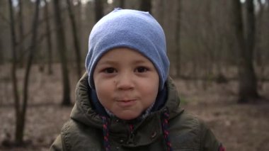 Ormanda kurabiye yiyen çocuk, yakın çekim, yavaş çekim.