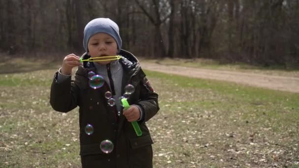 Petit garçon faire des bulles de savon dans le parc slow-mo 