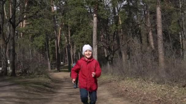 Pojke kör genom skogen på camera.slow mo — Stockvideo