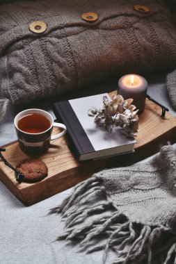 Sıcak bir çay, buhar, battaniye, kitap ve mumlarla dolu bir ev. Hygge ev içi.