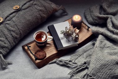 Sıcak bir çay, buhar, battaniye, kitap ve mumlarla dolu bir ev. Hygge ev içi.