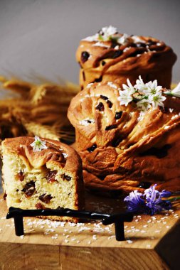 Tahtada beyaz çiçeklerle süslenmiş kuru üzümlü Paskalya ekmeği.