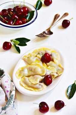 Beyaz tabakta kirazlı hamur tatlısı