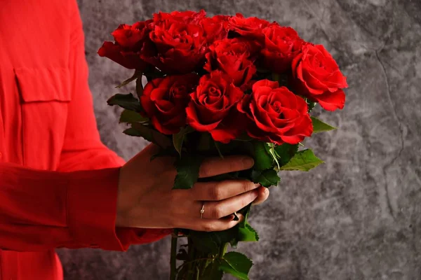 woman in red blouse with roses on grey background