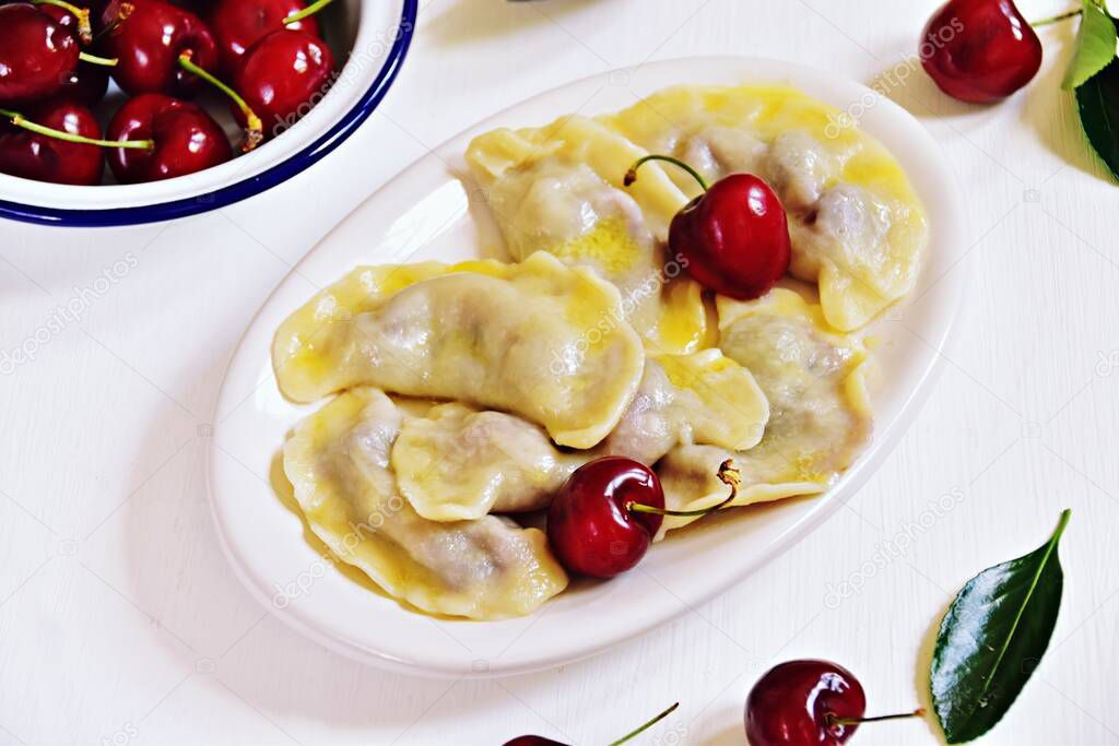 dumplings with cherries in white plate
