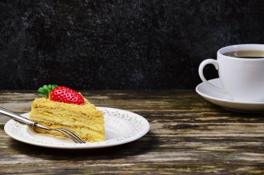 Koyu arkaplanda çilekli lezzetli bir pasta dilimi.. 