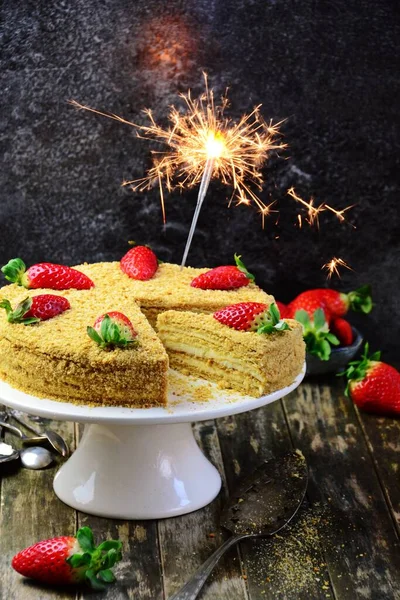 Honey cake with strawberry on the cake stand. Homemade cake cut and slice