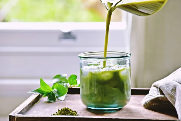 Bir bardak buzlu kibrit yeşil çay. Arka planda.