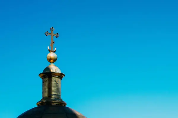 Cruz sobre una cúpula sobre un fondo de cielo azul . — Foto de Stock