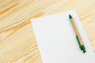 Beyaz kağıt mockup ahşap arka plan üzerinde kalem ile levha