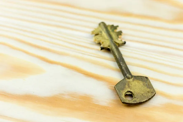 Close-up of old vintage key on wooden background