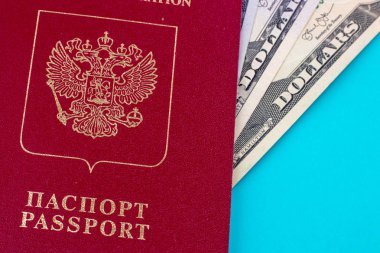 Kırmızı Rus pasaportu dolar faturaları üzerinde mavi arka plan ile. Seyahat kavramı
