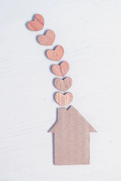 Abstrakcyjny tekturowy dom z sercami z pobliskiego drzewa. Koncepcja komfortu, rodzinnego ciepła. — Zdjęcie stockowe