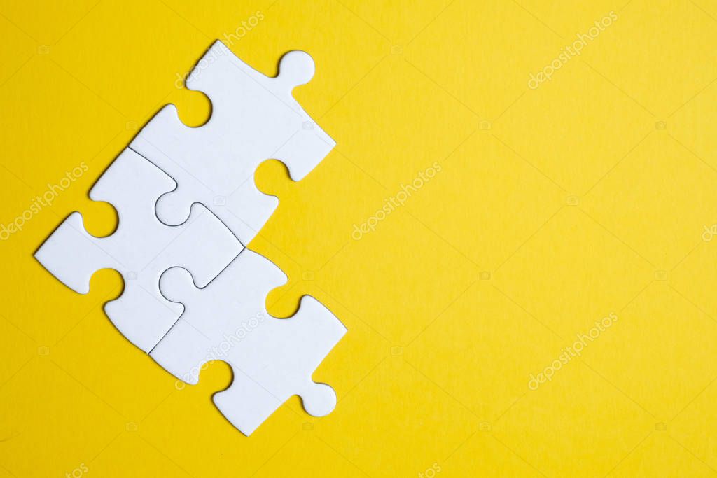 Three pieces of a puzzle united among themselves on a yellow background. Teamwork concept.