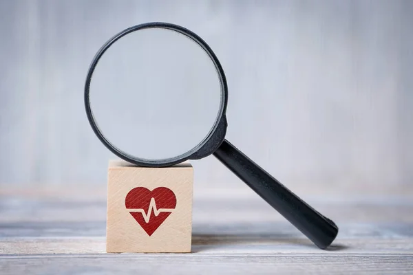 Cubo con corazón con icono de cardiograma y lupa. Concepto de búsqueda de información médica . — Foto de Stock