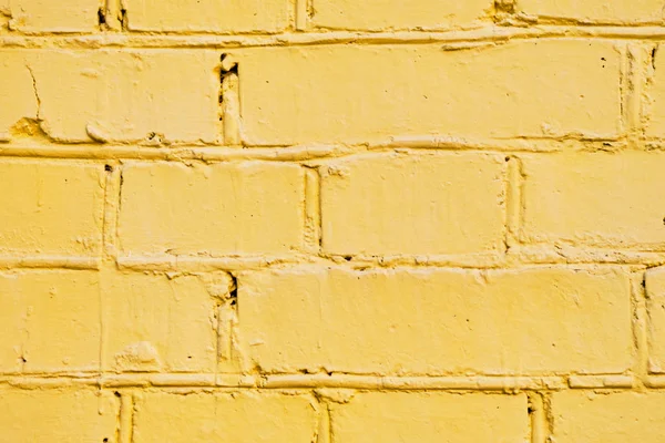 De bakstenen muur is geel geschilderd. Achtergrond. — Stockfoto