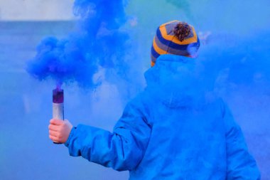 January 05, 2019, St. Petersburg: A child in warm clothes runs holding in his hand with a fireworks of blue.