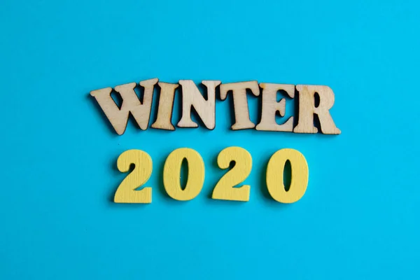 Le concept de l'hiver dans la nouvelle année. Numéros en bois 2020 avec lettres sur fond bleu. Vue du dessus . — Photo