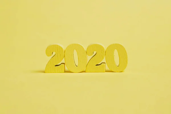 Figure di legno 2020 su sfondo giallo . — Foto Stock