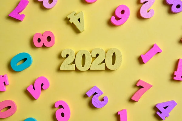 En bois 2020 à côté des chiffres colorés sur le fond jaune. Vue du dessus . — Photo