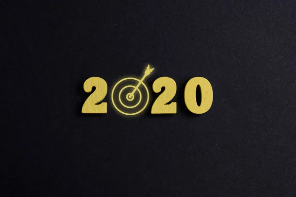 Begreppet uppnående av målen 2020. Trä figurer på svart bakgrund. Ovanifrån. — Stockfoto