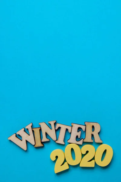 The concept of winter in the new year. Wooden numbers 2020 with letters on a blue background. Top view. Vertical. — 스톡 사진