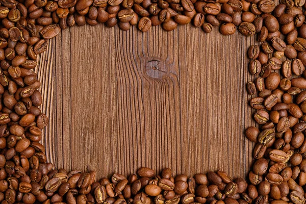 Kaffeebohnen bilden einen Rahmen für einen Ort mit Text auf Holzgrund. — Stockfoto