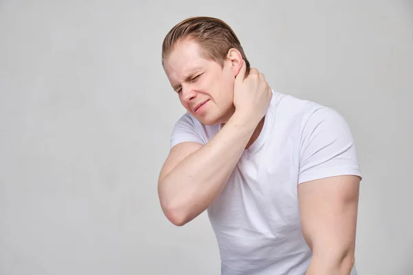 En man håller nacken med handen. Begreppet smärta, ostechnodrosis. — Stockfoto
