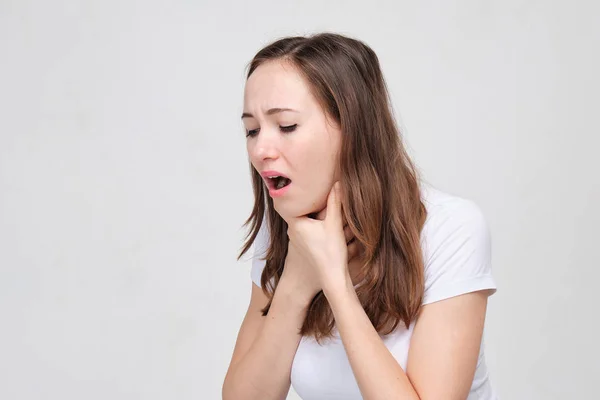 Una ragazza con una maglietta bianca soffre di soffocamento. Problemi respiratori e polmonari. Concetto di asma . — Foto Stock