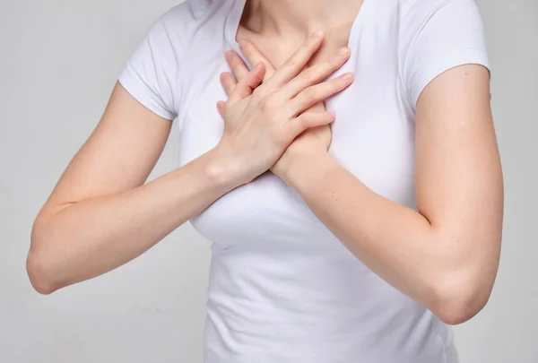 A girl in a white T-shirt suffers from chest pain. Difficulty breathing. — Stock Photo, Image