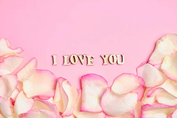 The inscription I love you in the center with copy space of a background of rose petals in white and pink. Paper background. — ストック写真