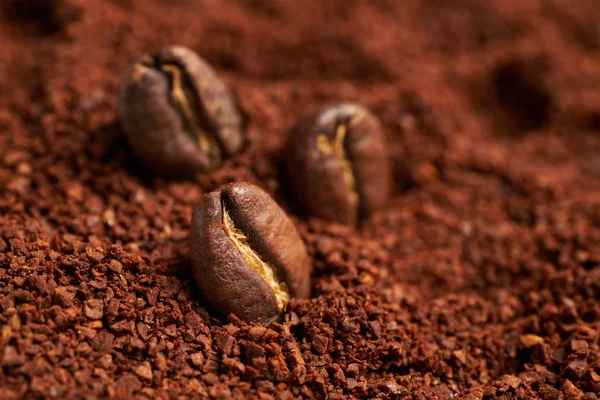 roasted beans lie on ground coffee.