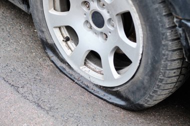 Broken, deflated and damaged car wheel.