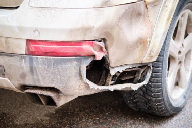 Spoiled and broken car bumper in the city.