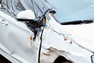 Cars after an accident with a damaged side mirror and door.