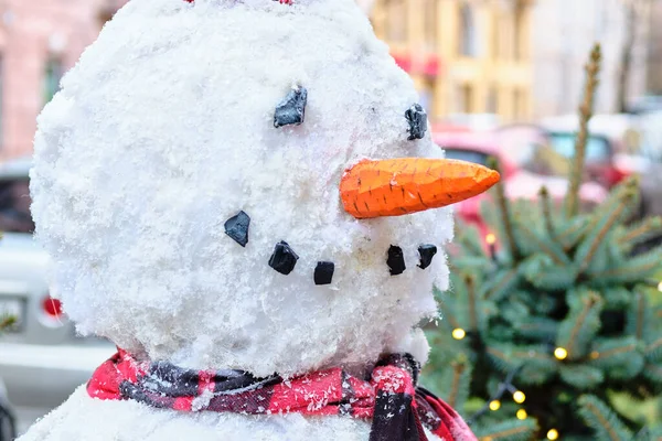 Sneeuwman 's hoofd met een wortelneus in de stad. — Stockfoto