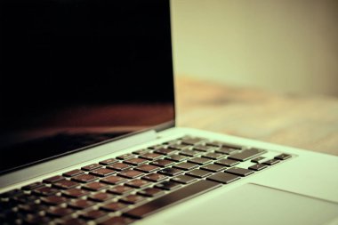 Laptop on a wooden table. Toned.