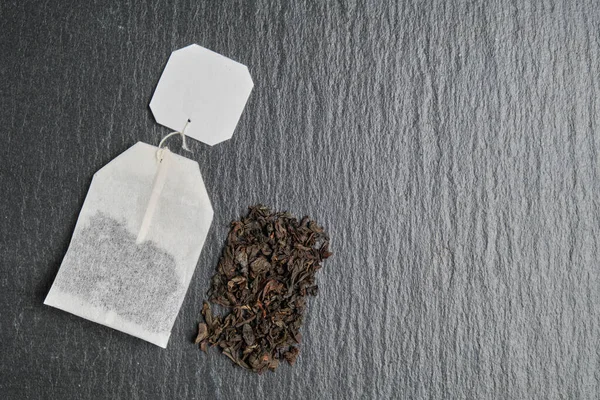 Immagine astratta del contenuto di una bustina di tè nero sullo sfondo di una lavagna . — Foto Stock
