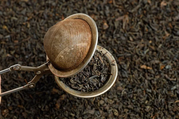 The brewing insment is open against the backdrop of black tea. — 图库照片