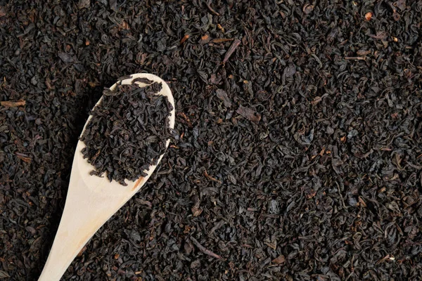 Száraz fekete tea fából készült kanállal. Másolás. felülnézet — Stock Fotó