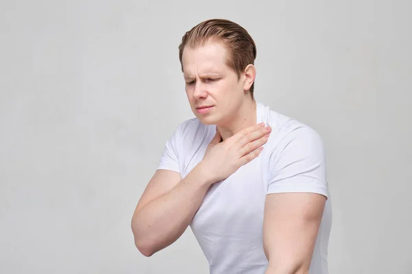 A man in a white T-shirt feels ill health. Weakening of the body and weakness. — Stok fotoğraf