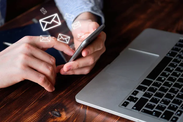 The concept of exchanging emails. A man works in a smartphone.