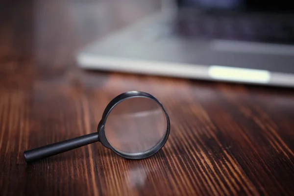 Un concetto astratto di lente d'ingrandimento e laptop come ricerca di informazioni in un tirocinante per le imprese . — Foto Stock