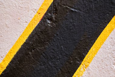 Abstract texture of plaster beige, black with a yellow stripe.