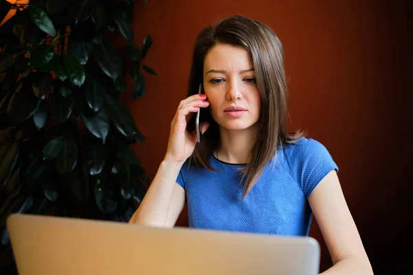 Ένα κορίτσι ντυμένο με μπλε φόρεμα μιλάει στο τηλέφωνο και ανακρίνει έναν πιθανό υπάλληλο.. — Φωτογραφία Αρχείου