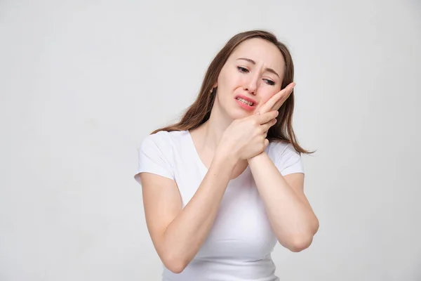 Porträt eines Mädchens im weißen T-Shirt, das an den Folgen einer missglückten Zahnoperation leidet. Zahnschmerzen. — Stockfoto