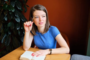 Girl student plans her day with study writing in a notebook.